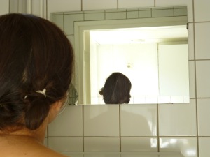 Vrouw kijkt in spiegel
